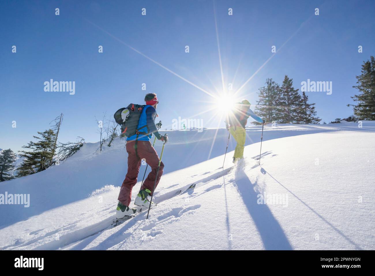 Sciatori che arrampicano la montagna di neve contro il cielo Foto Stock