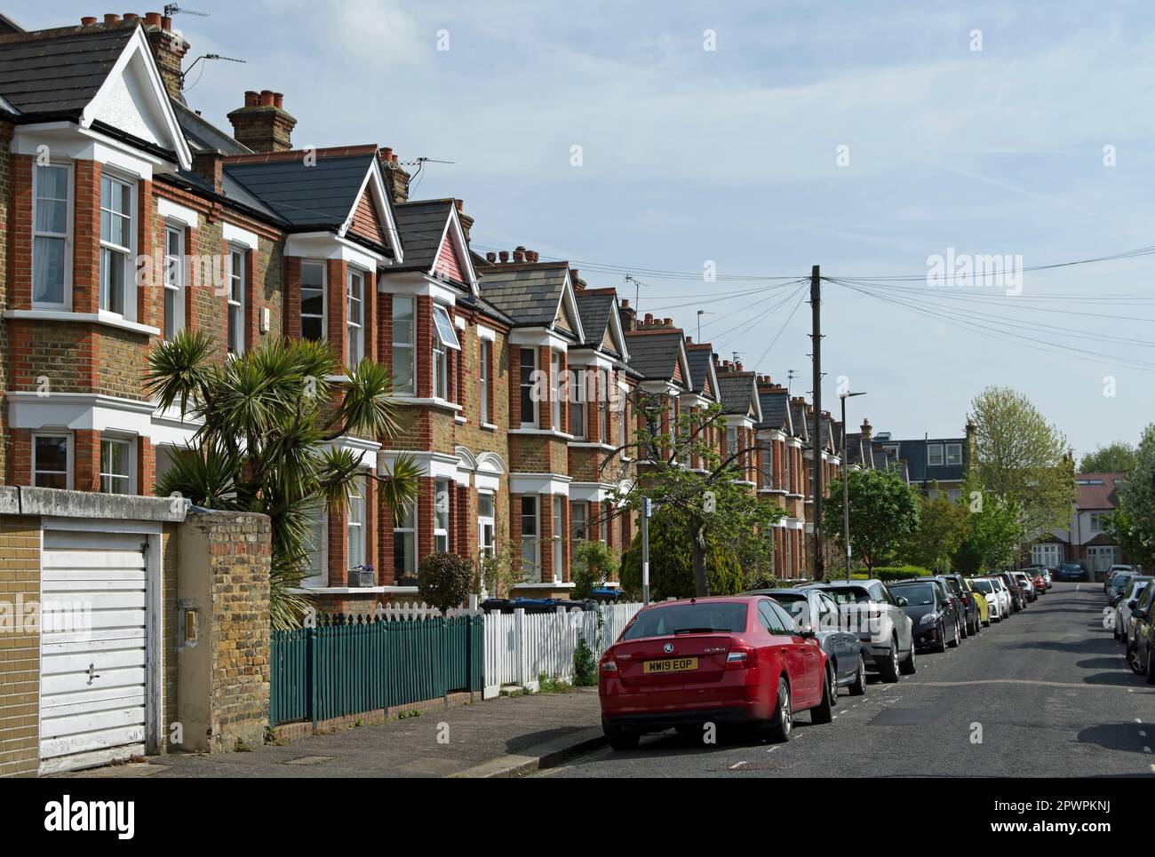 fila di case vittoriane tardive, terrazzate con fronte baia e corridoi adiacenti, in raynes park, sud-ovest di londra, inghilterra Foto Stock