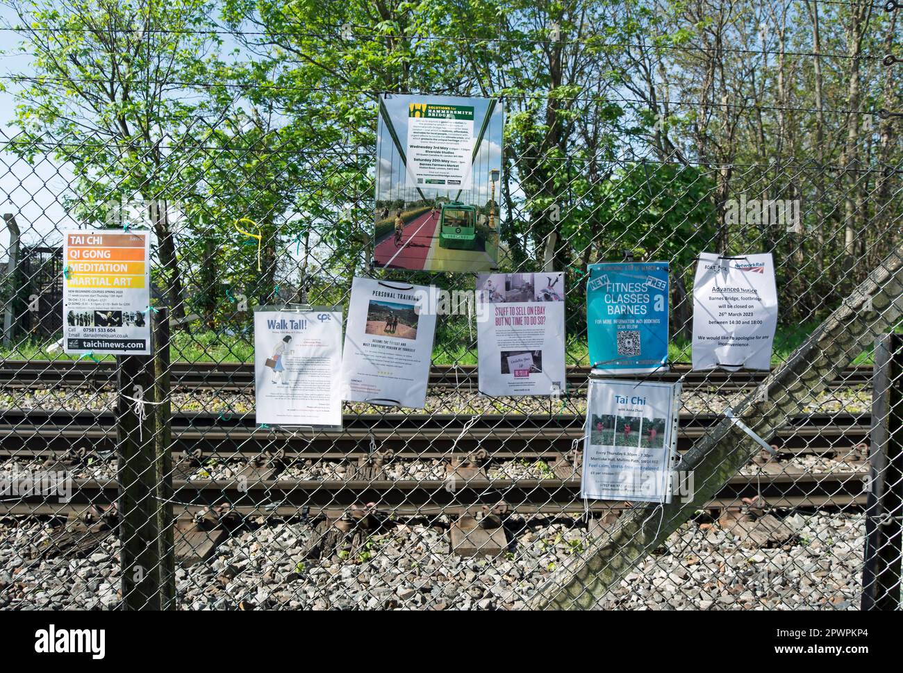su una recinzione accanto al sentiero che attraversa il ponte ferroviario di barnes, barnes, londra sud-occidentale, inghilterra, volantini pubblicizzare classi, eventi e imprese Foto Stock