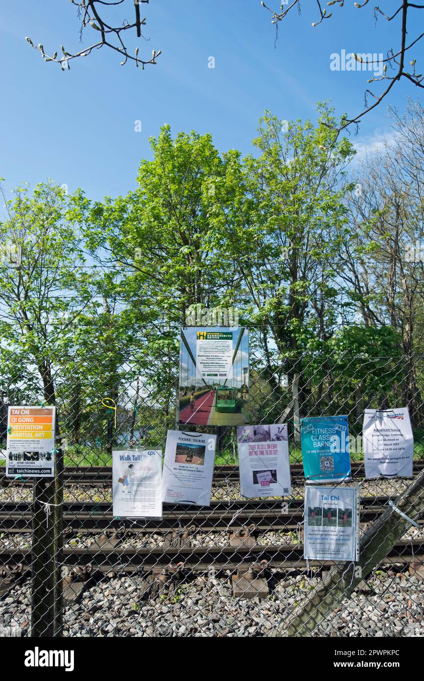su una recinzione accanto al sentiero che attraversa il ponte ferroviario di barnes, barnes, londra sud-occidentale, inghilterra, volantini pubblicizzare classi, eventi e imprese Foto Stock