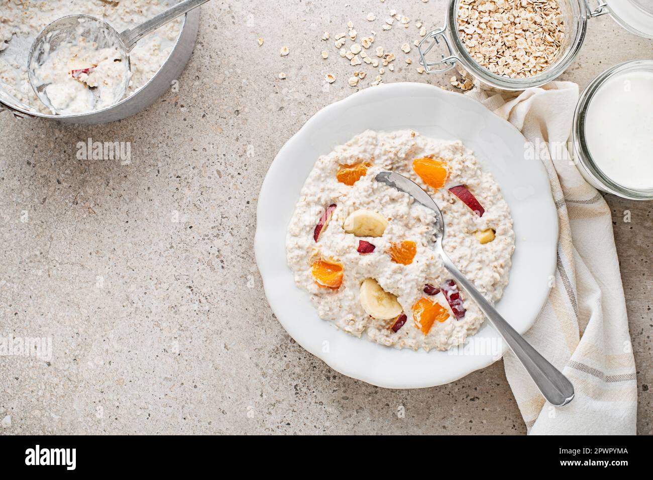 Piatto di farina d'avena. Un piatto di farinata d'avena servito con frutta fresca e latte. Cibo sano, dieta. Vista dall'alto. Foto Stock