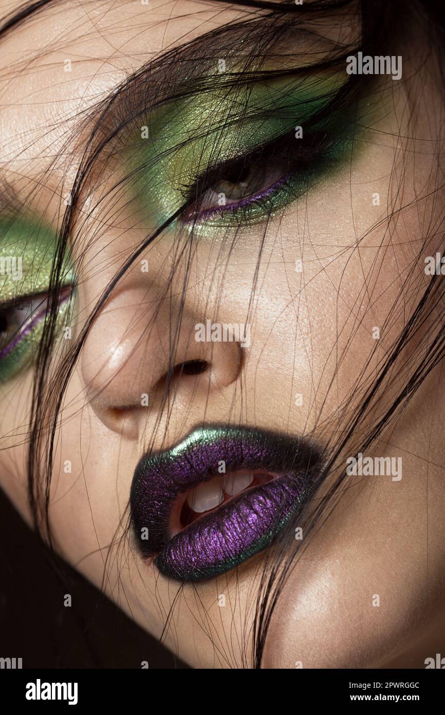 Bellissima ragazza con molla verde e per il trucco delle labbra del vampiro. Bellezza viso. Le foto in studio Foto Stock