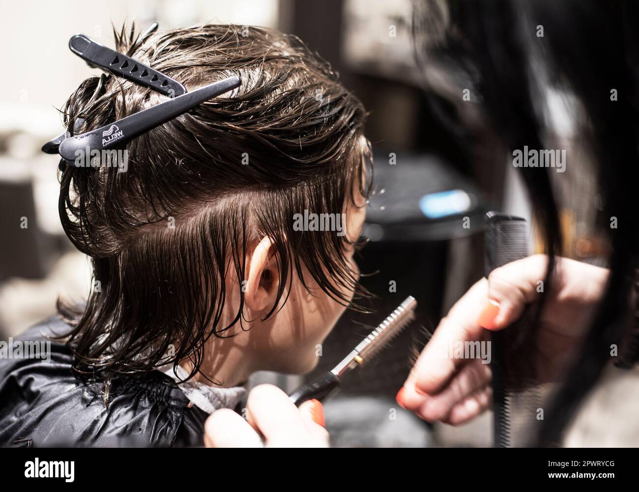 barbershop taglia i capelli puliti bagnati sotto un coltello ad un adolescente Foto Stock