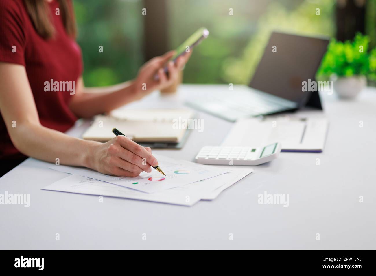 Concetto di business ufficio donna che lavora, Closeup businesswoman che controlla il suo piano di investimento con l'analisi di documenti e dati grafici di investimento aziendale Foto Stock