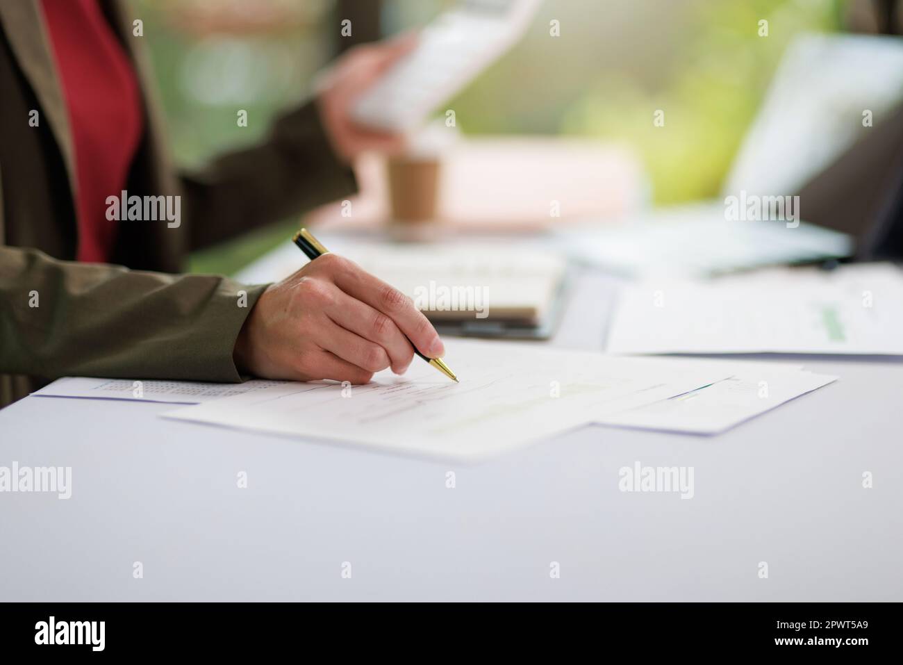 Concetto di business ufficio donna che lavora, Closeup businesswoman che controlla il suo piano di investimento con l'analisi di documenti e dati grafici di investimento aziendale Foto Stock