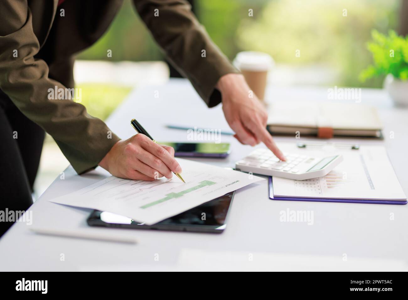 Concetto di business ufficio donna che lavora, Closeup businesswoman che controlla il suo piano di investimento con l'analisi di documenti e dati grafici di investimento aziendale Foto Stock