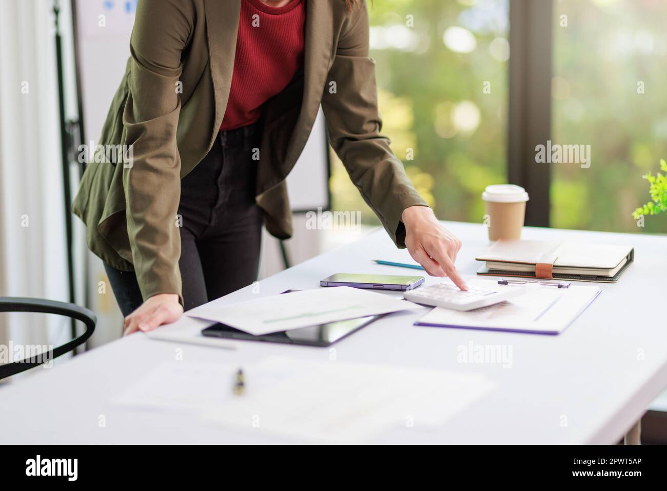 Concetto di business ufficio donna che lavora, Closeup businesswoman che controlla il suo piano di investimento con l'analisi di documenti e dati grafici di investimento aziendale Foto Stock