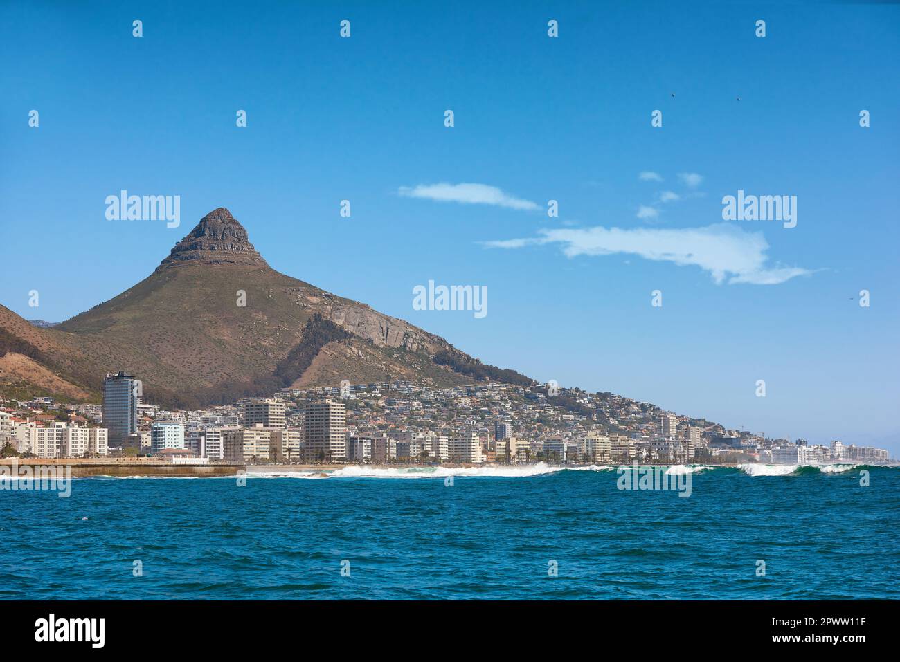 Vista costiera di Città del Capo e paesaggio montano in una giornata di sole. Vista dell'oceano e della città su un orizzonte blu. Una destinazione di viaggio popolare per t Foto Stock