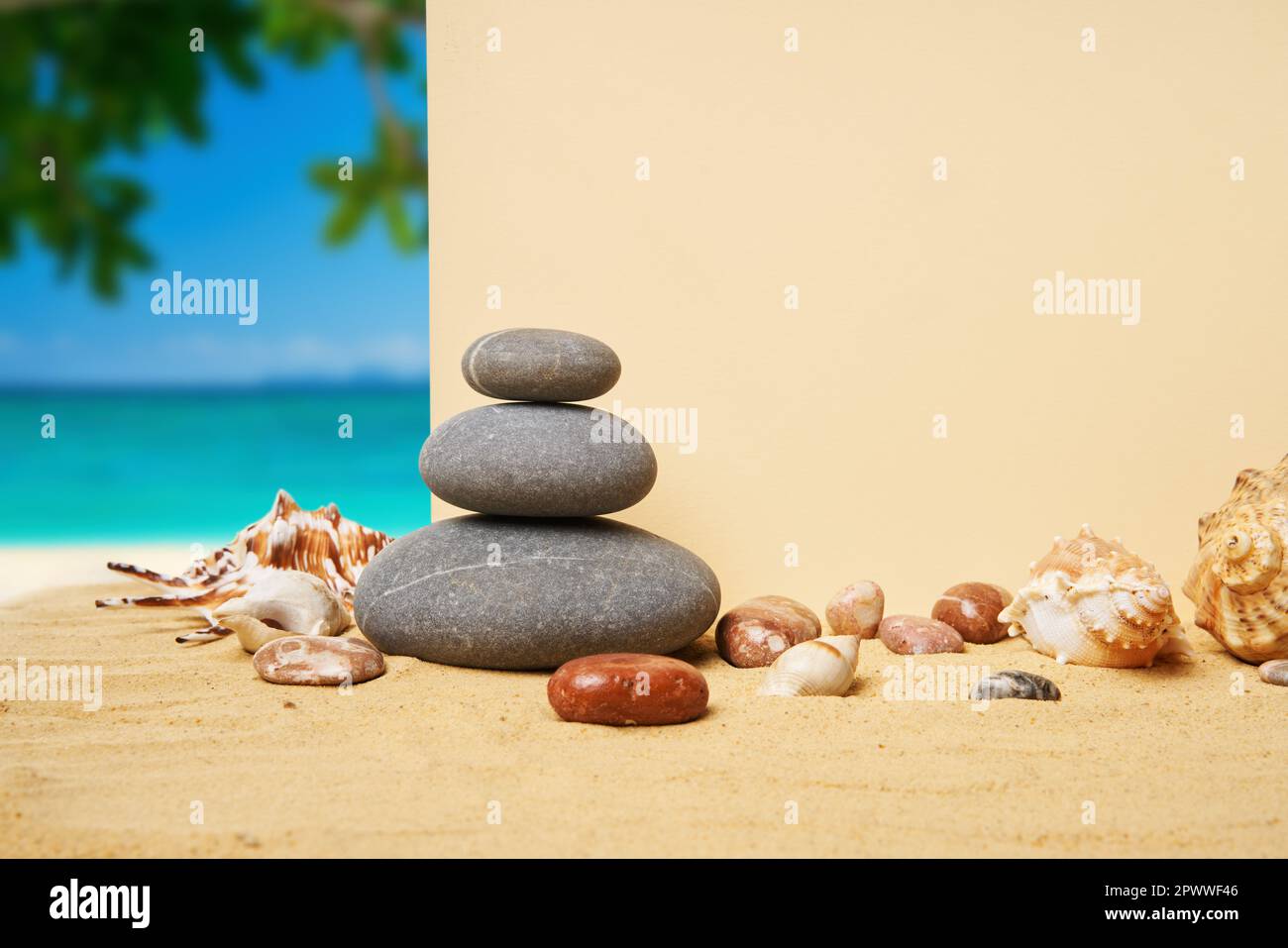 Invito o biglietto d'auguri mockup con conchiglie e piramide di pietre sulla spiaggia di sabbia estiva sullo sfondo dell'oceano. Concetto di vacanza, spazio copia Foto Stock