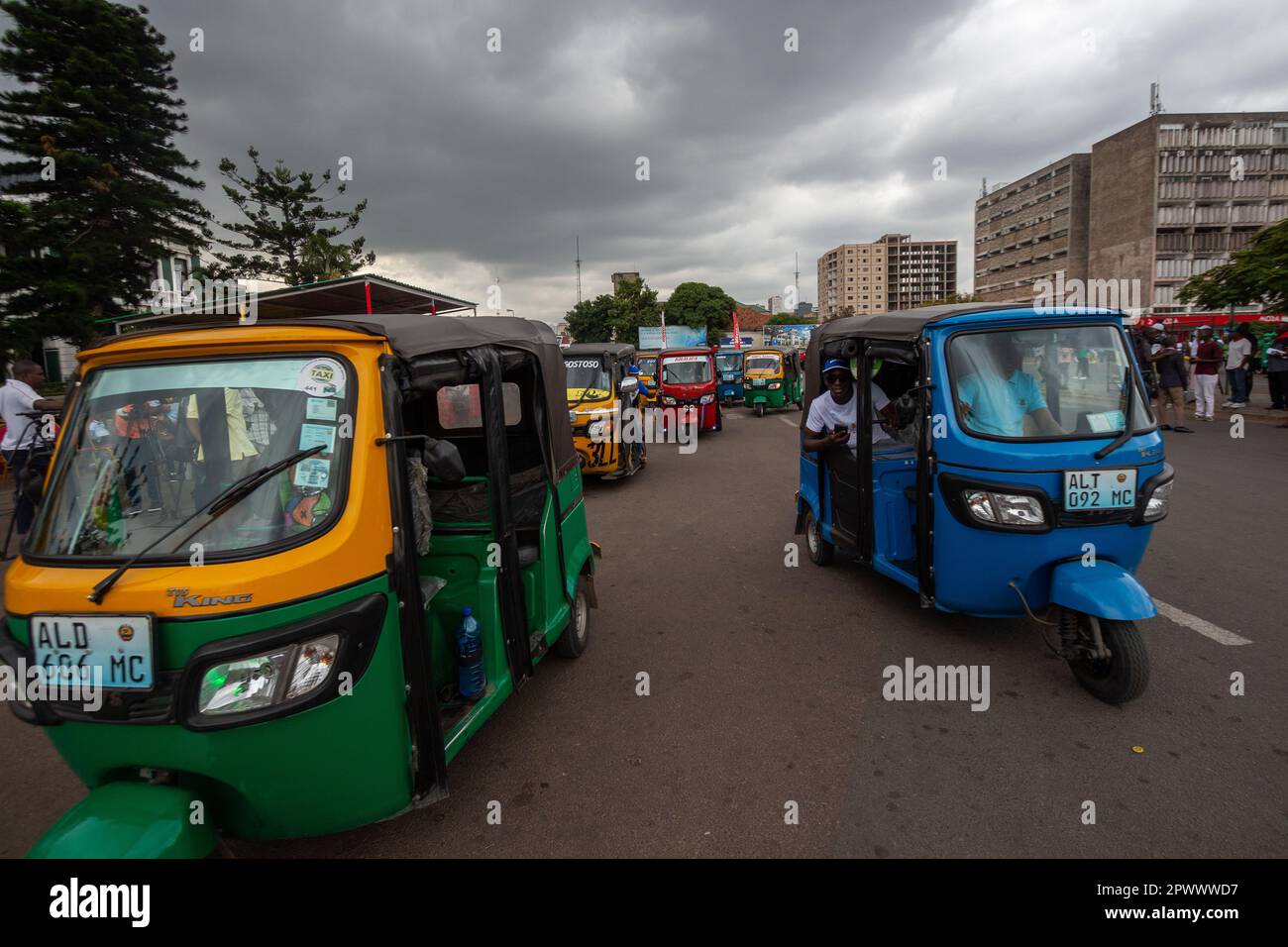 I veicoli a tre ruote si riuniscono di fronte alla storica stazione ferroviaria centrale di Maputo Foto Stock