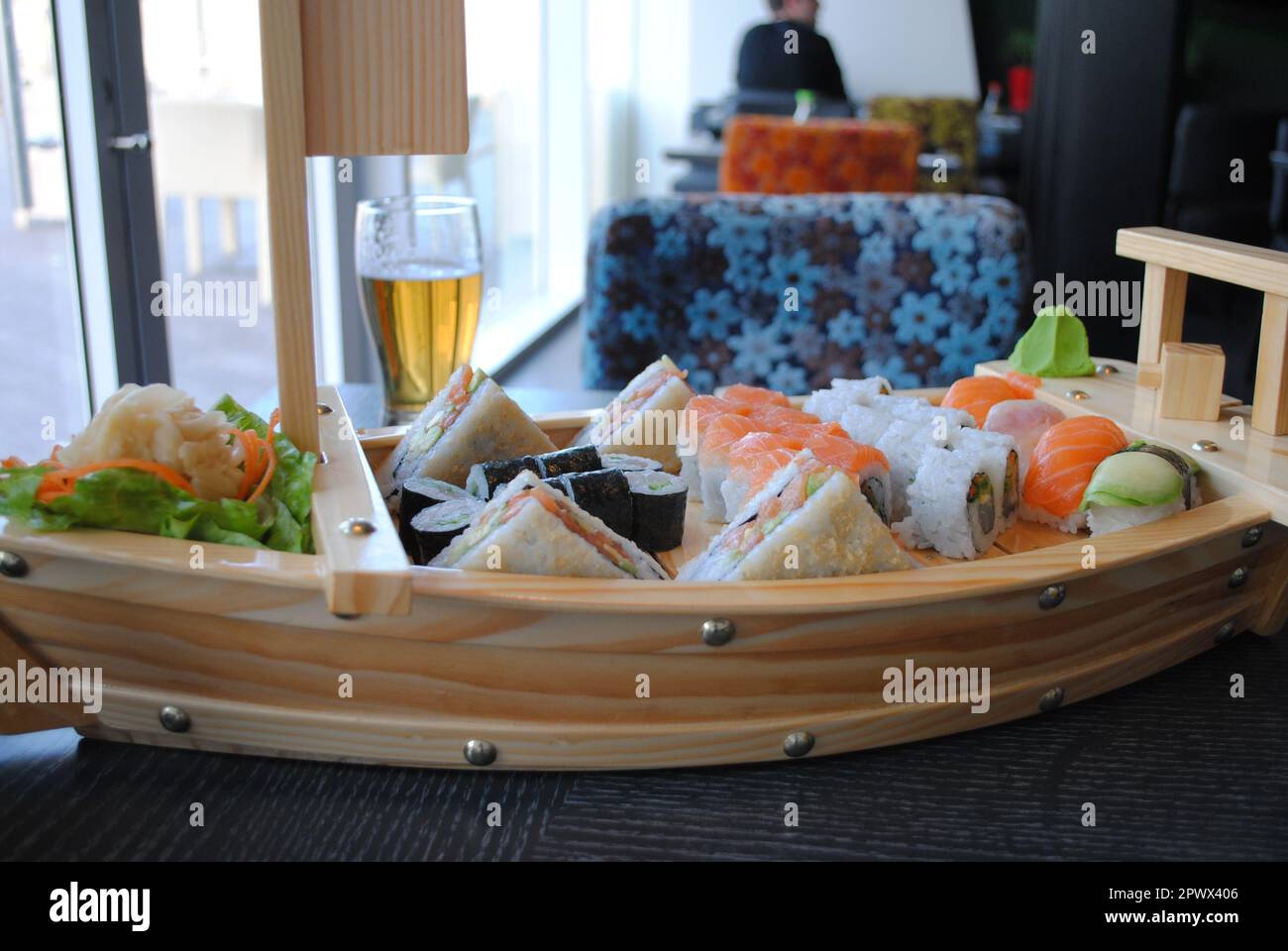 Sushi e panini allestiti nel Boat bar da legno recuperato con un bicchiere di birra in un ristorante di pesce Foto Stock