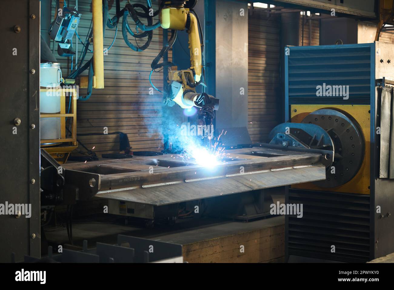 Macchina industriale automatizzata durante il processo di saldatura ad arco e la creazione di nuovi articoli in una grande officina di impianti di produzione di macchinari Foto Stock