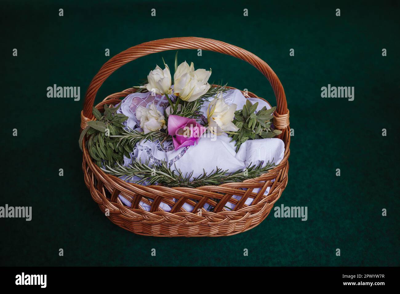Cestino pasquale su sfondo turchese, decorato con fiori e contenente cibi pasquali, pronto per essere portato in chiesa per la benedizione pasquale Foto Stock