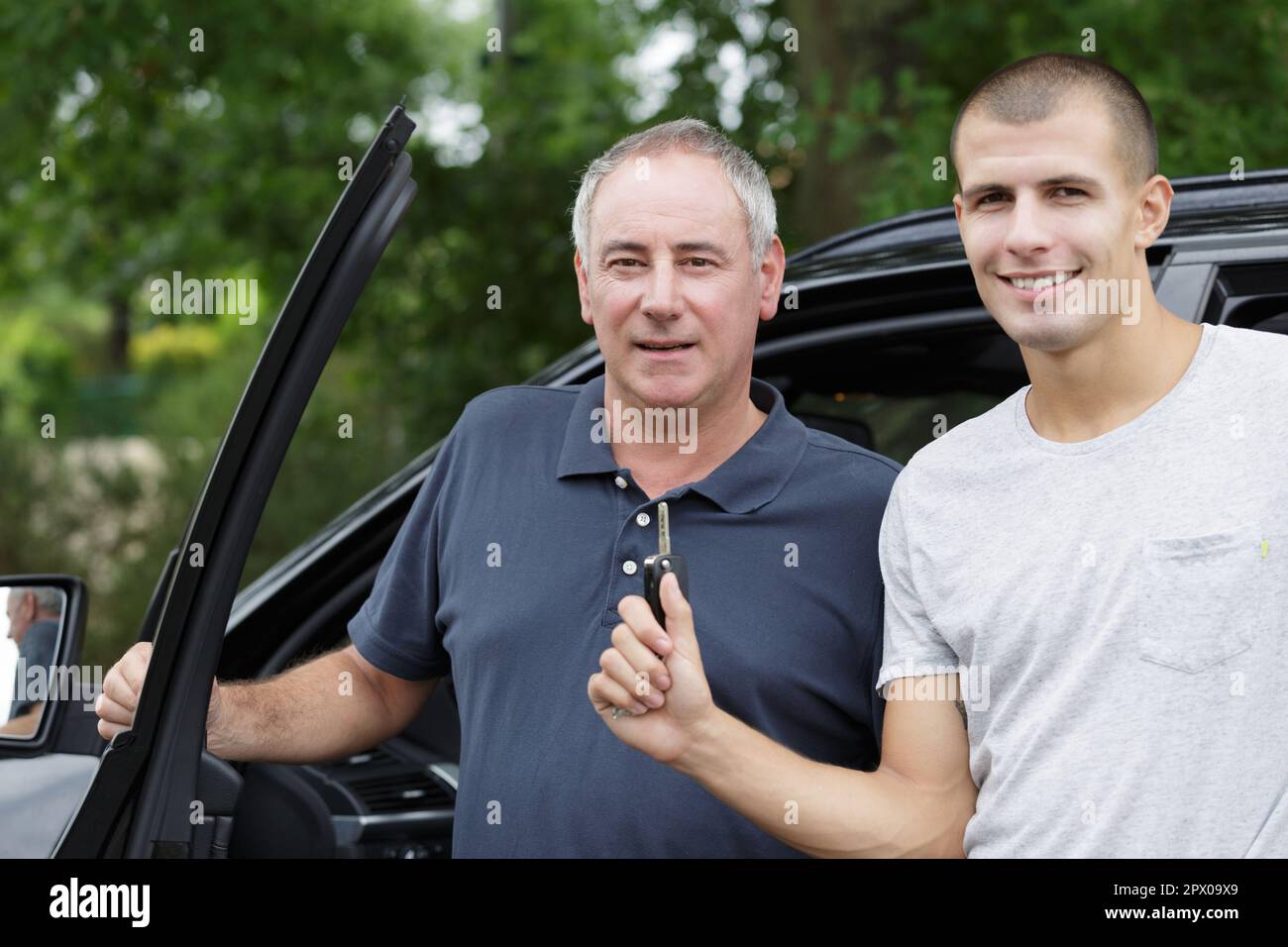 padre e figlio si trovavano accanto al figlio dell'auto che teneva le chiavi Foto Stock