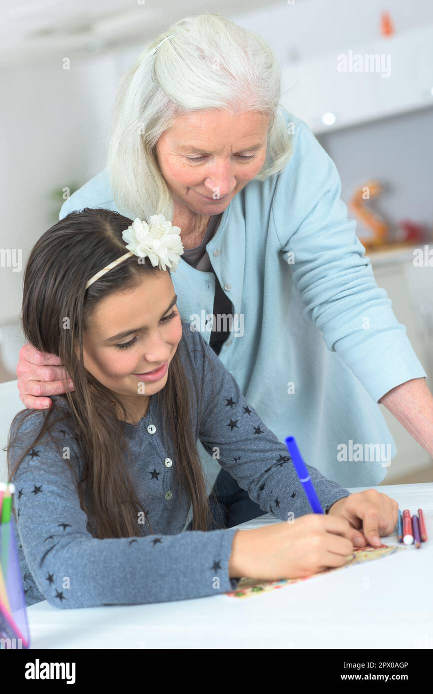 Nonna accanto a nonna che sta colorando dentro Foto Stock