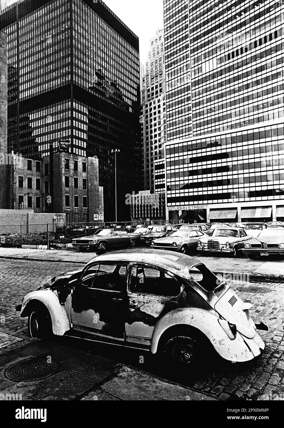 AJAXNETPHOTO. LUGLIO, 1975. NEW YORK, STATI UNITI. - LOWER MANHATTAN - UNA VOLKSWAGEN AUTO BRUCIATA ABBANDONATA SU WATER STREET GUARDANDO VERSO 127 JOHN STREET. PHOTO:JONATHAN EASTLAND/AJAXREF:232404 119 Foto Stock