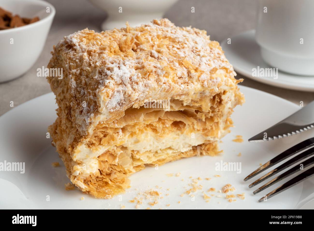 Un pezzo di torta Napoleone su un piatto. Dolce delizioso dessert di pasta sfoglia con crema pasticcera. Foto Stock