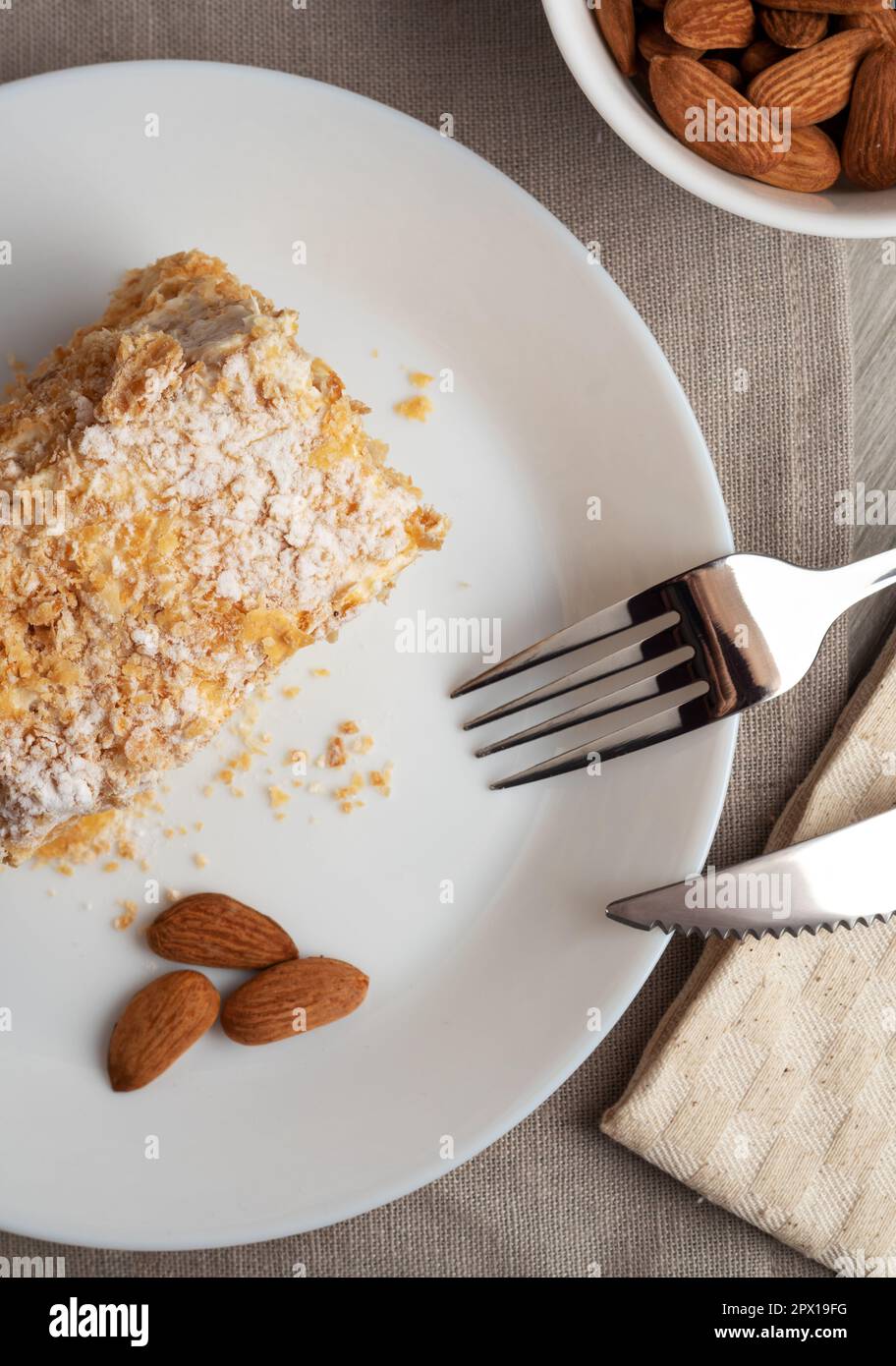 Un pezzo di torta Napoleone su un piatto. Dolce delizioso dessert di pasta sfoglia con crema pasticcera. Foto Stock