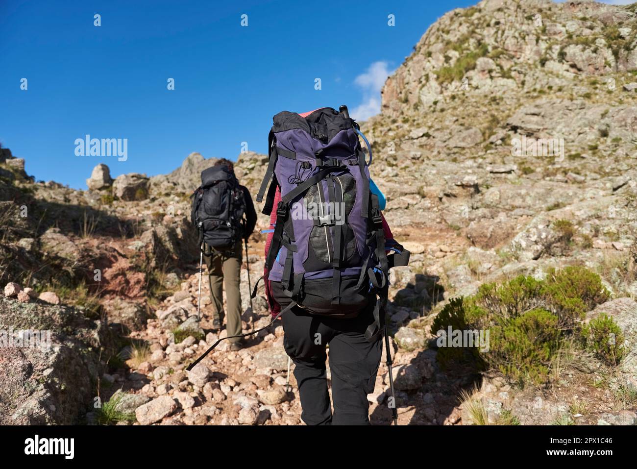 Alpinisti irriconoscibili che camminano su un sentiero in mezzo a un paesaggio roccioso di montagna a Los Gigantes, Cordoba, Argentina, una destinazione turistica ideale. Foto Stock