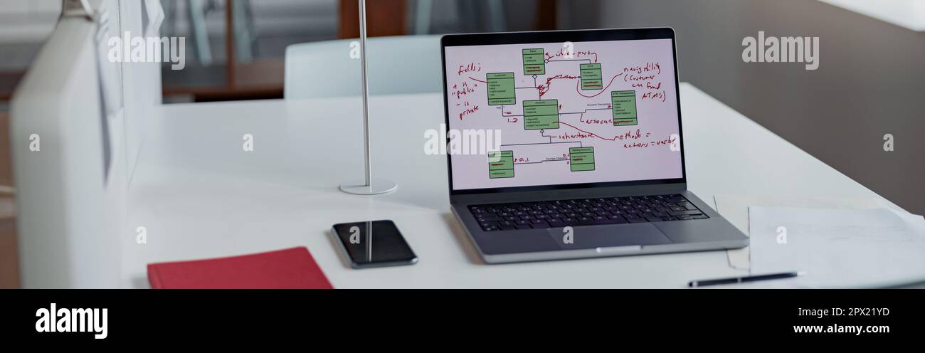 Scrivania da ufficio con computer portatile, telefono e documenti sul tavolo in un ufficio moderno Foto Stock