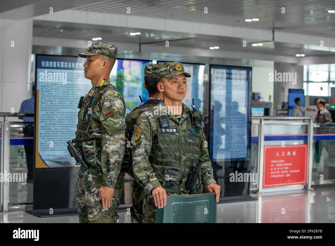 BEIHAI, CINA - 30 APRILE 2023 - poliziotti d'armamento pattugliano l'ingresso di una stazione ferroviaria ad alta velocità durante la festa di maggio nella città di Beihai, Foto Stock