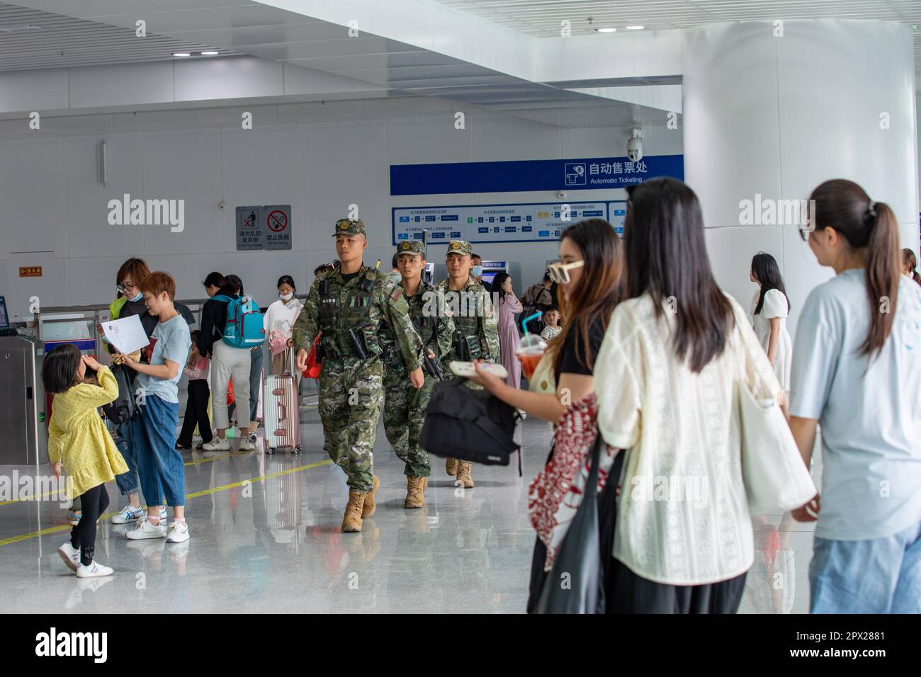 BEIHAI, CINA - 30 APRILE 2023 - poliziotti d'armamento pattugliano l'ingresso di una stazione ferroviaria ad alta velocità durante la festa di maggio nella città di Beihai, Foto Stock