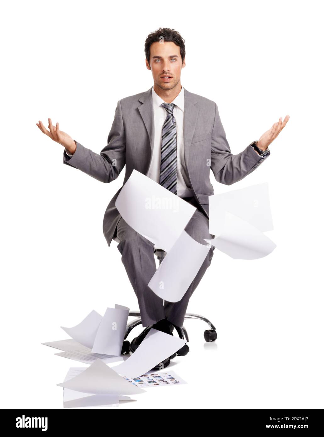 Qualunque cosa... io sono così sopra questo... Un bel giovane uomo d'affari che fruga mentre i suoi documenti cadono al pavimento. Foto Stock