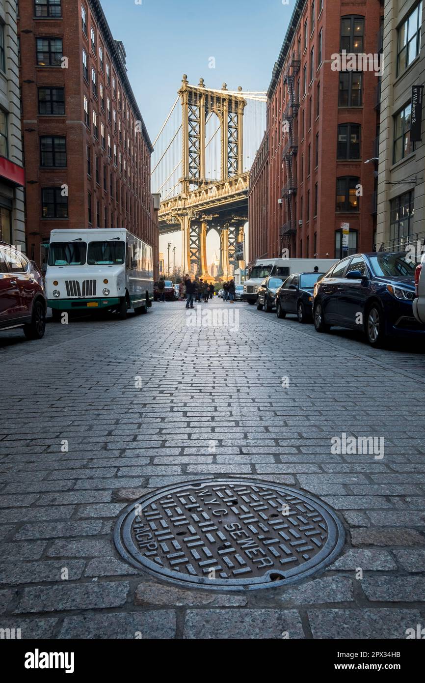 Manhattan, New York, USA - Dicembre 11th 2018: Ponte di Brooklyn visto dalla zona di D.U.M.B.O. con più auto parcheggiate su ogni lato della strada Foto Stock