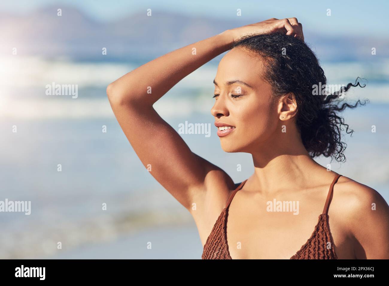 Sabbia tra le dita dei piedi e l'aria da spiaggia contro il mio viso. una bella giovane donna che trascorre la giornata in spiaggia Foto Stock