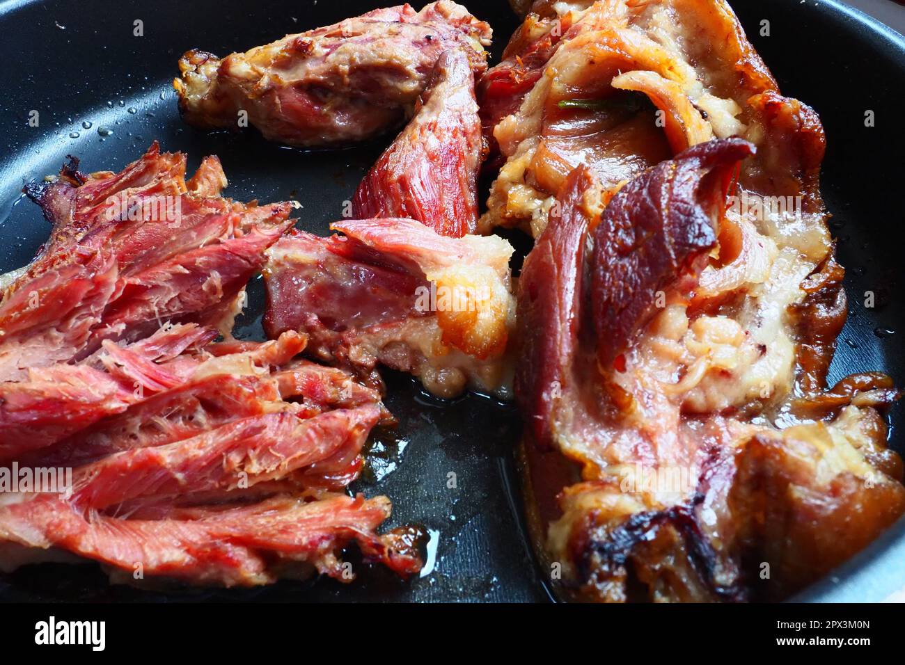 Spalla o ginocchio di maiale affumicato arrosto. Carne deliziosa su una teglia nera con gocce di olio vegetale, tolti dal forno. Delicatezza di maiale per din Foto Stock