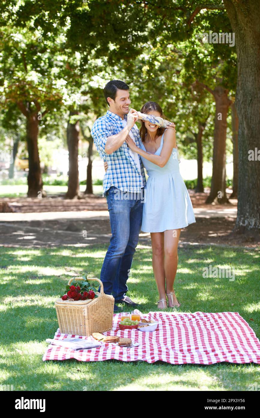 Sorprese romantiche. Una giovane donna bendata che ride con il suo ragazzo  nel parco Foto stock - Alamy