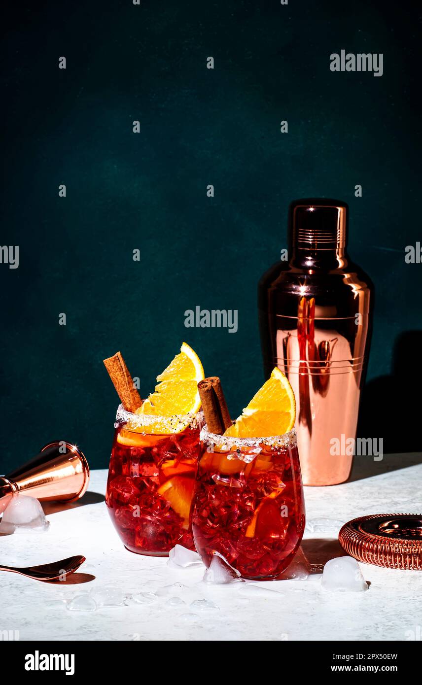 Cocktail Negroni mezcalito con mezcal messicano, vermouth, amaro, liquore  alle erbe, arancia, Cannella e ghiaccio. Fondo verde scuro, chiaro duro e  Foto stock - Alamy