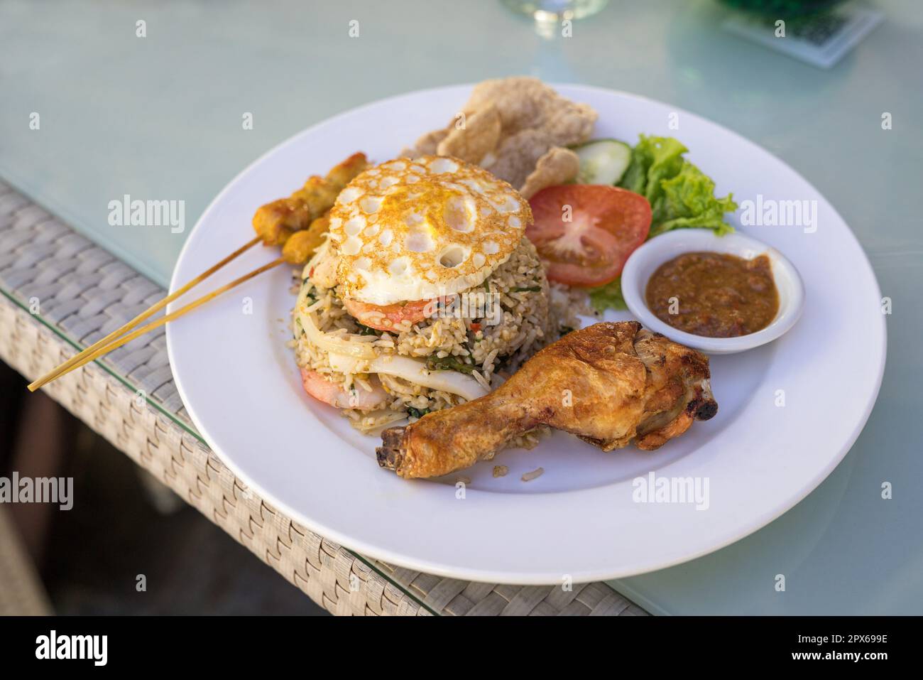 Riso fritto servito con pollo fritto, uova fritte e satay. Stile Asiatico. Foto Stock