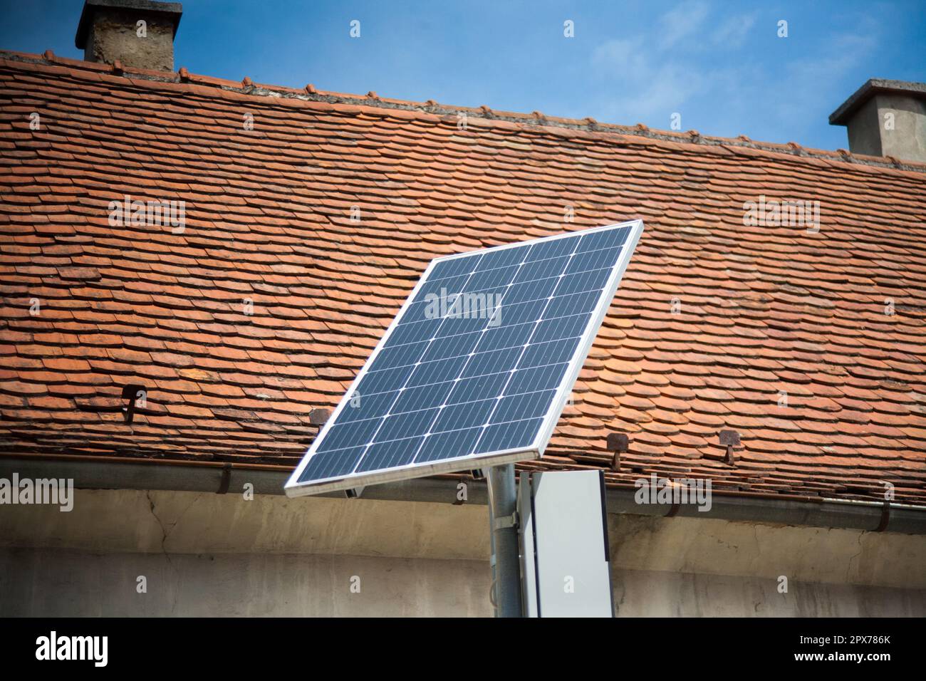 Pannelli solari installati in strada. Tetto rosso dietro. Foto Stock
