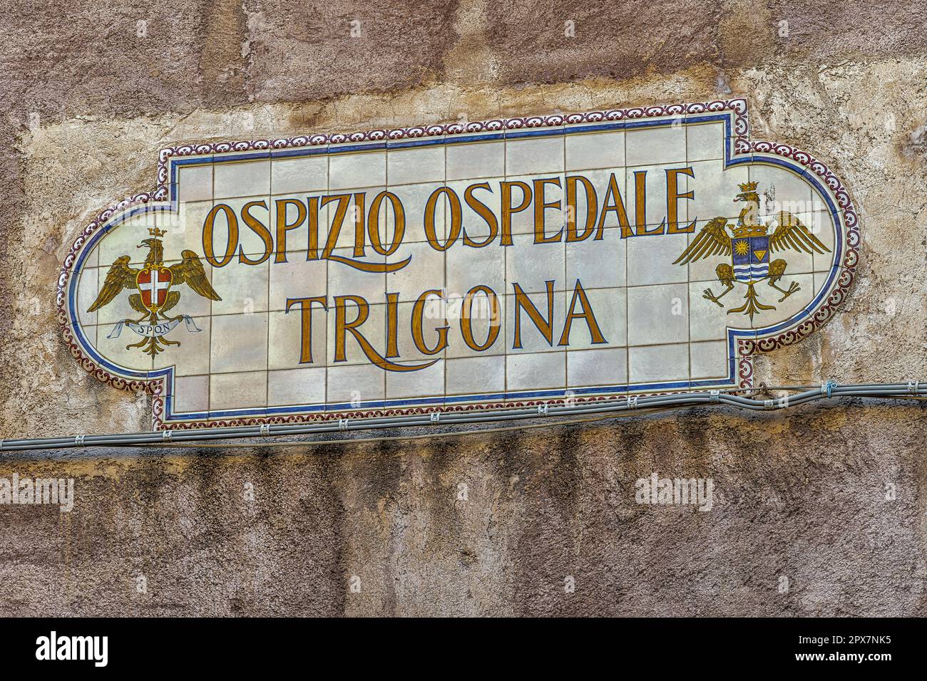 Le vecchie piastrelle accanto all'ingresso dell'edificio storico indicano l'omonimo ospedale che era anche una casa di lavoro. Noto, Sicilia Foto Stock