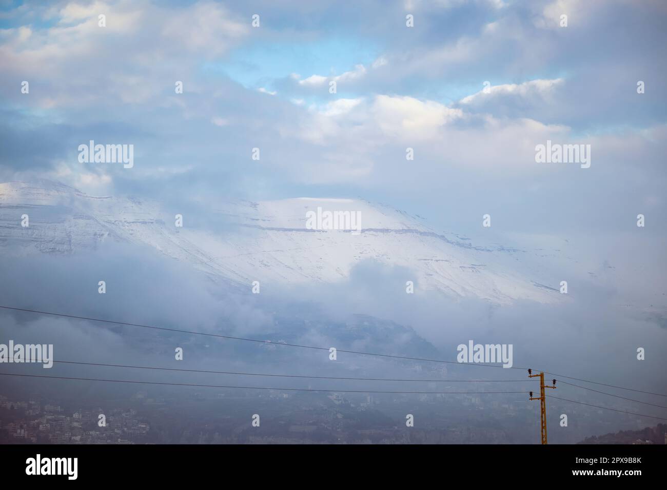 Splendido paesaggio di un'alta montagna coperta di neve in tempo Stormy. Villaggio montagnoso. Stazione sciistica. Libano Foto Stock