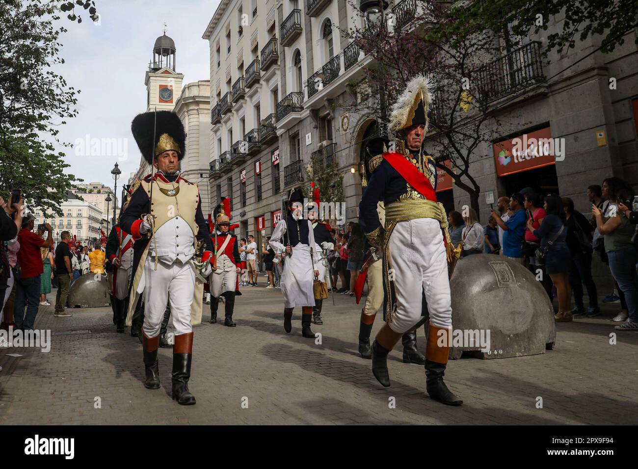 Due attori, vestiti con costumi da soldato francesi, camminano attraverso la Puerta del Sol, dietro la costruzione della presidenza della Comunità di Madrid. Madrid ha ospitato questa Domenica, 30 aprile, la ricostruzione storica della rivolta del 2 maggio. Le attività si sono svolte durante tutta la giornata in punti specifici della città. Al mattino nel parco del Retiro e nel pomeriggio da questo luogo a Plaza de Oriente fermandosi in punti come Puerta del Sol, via Alcala o Plaza Mayor. Migliaia di persone sono venuti a vedere questa ricreazione, in cui centinaia di attori vestiti in costumi d'epoca hanno p Foto Stock