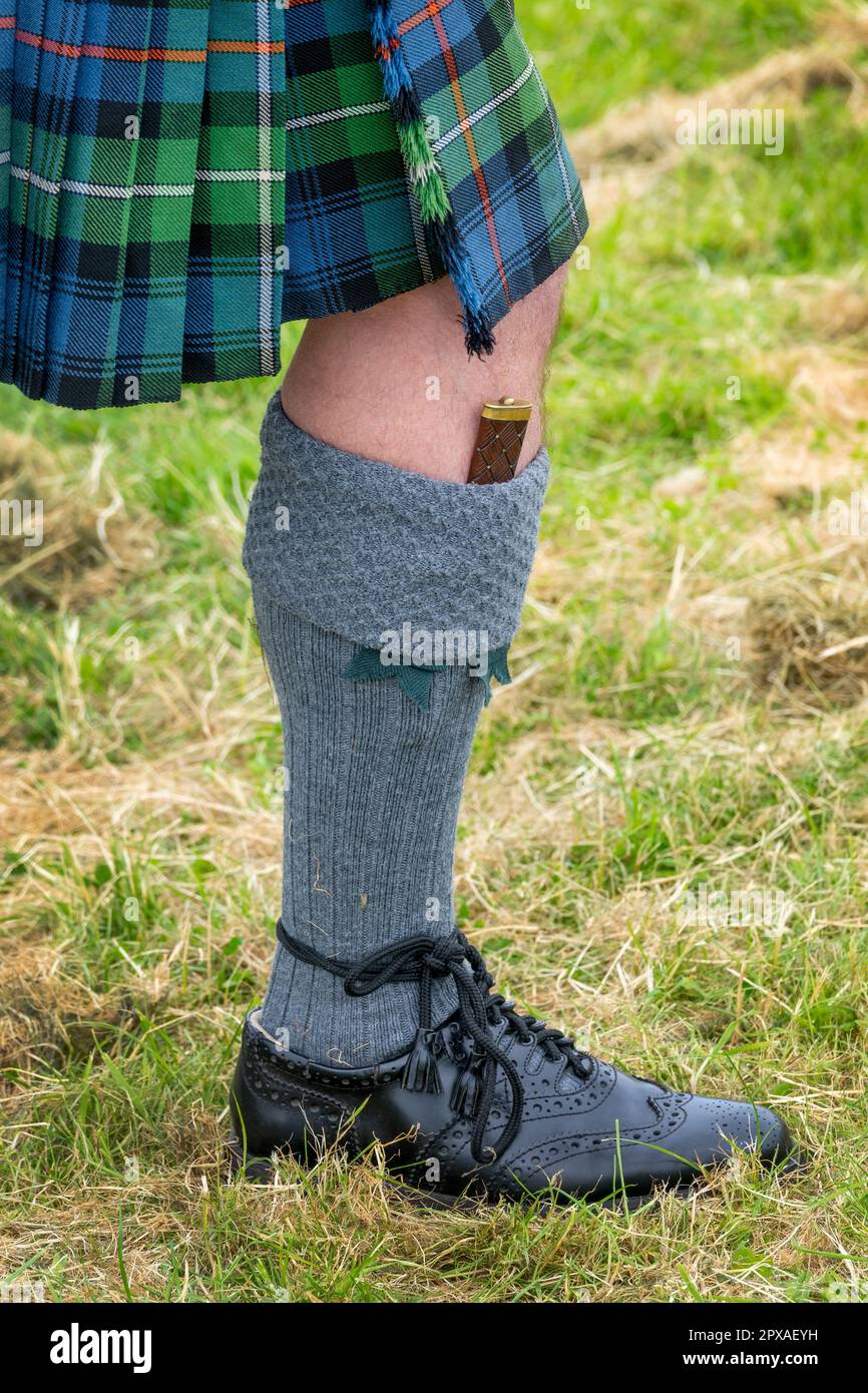 Abito tipico delle Highland con kilt, calze in kilt, calze in kilt flash, coltello gian Dubh e scarpe in pelle scozzese Ghillie brogues kilt Foto Stock