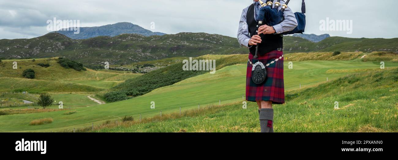 Bagpiper scozzese nelle Highlands della Scozia, montagne panoramiche sfondo paesaggio, Regno Unito Foto Stock