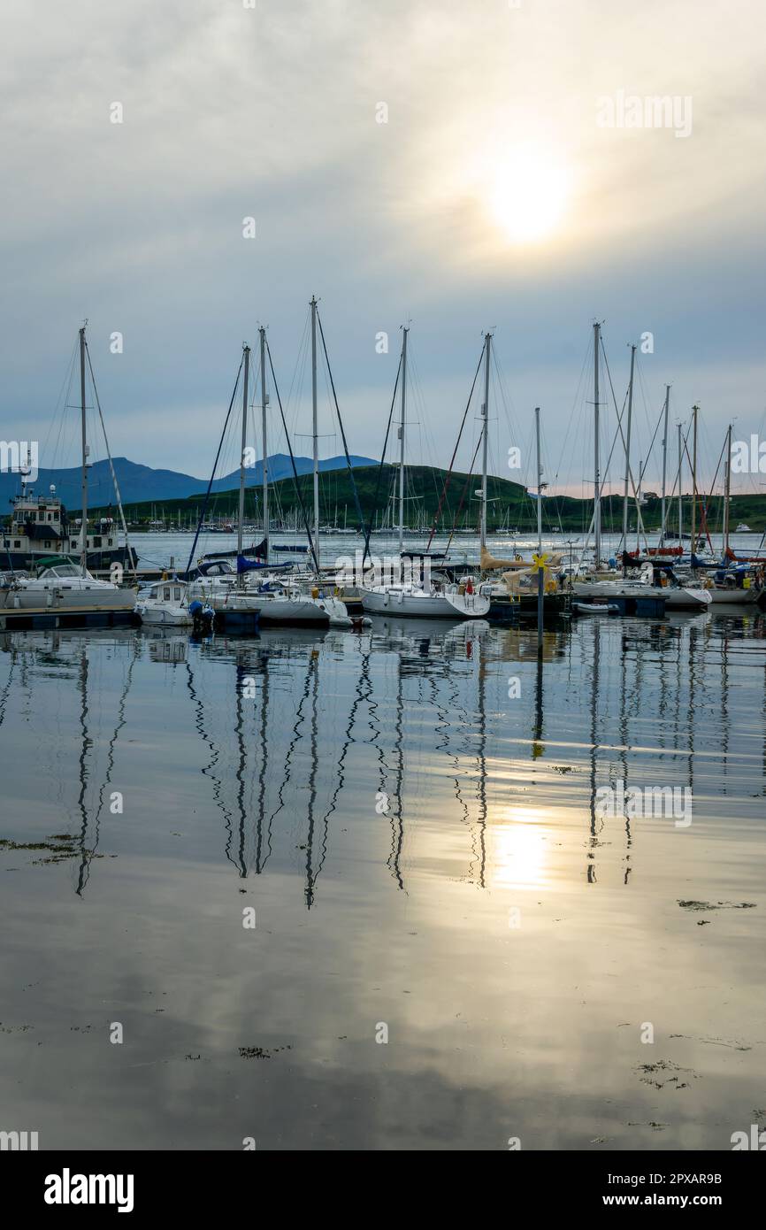 Le barche si riflettono nel porto di Oban al tramonto, ad Argyll, Scozia, Regno Unito Foto Stock