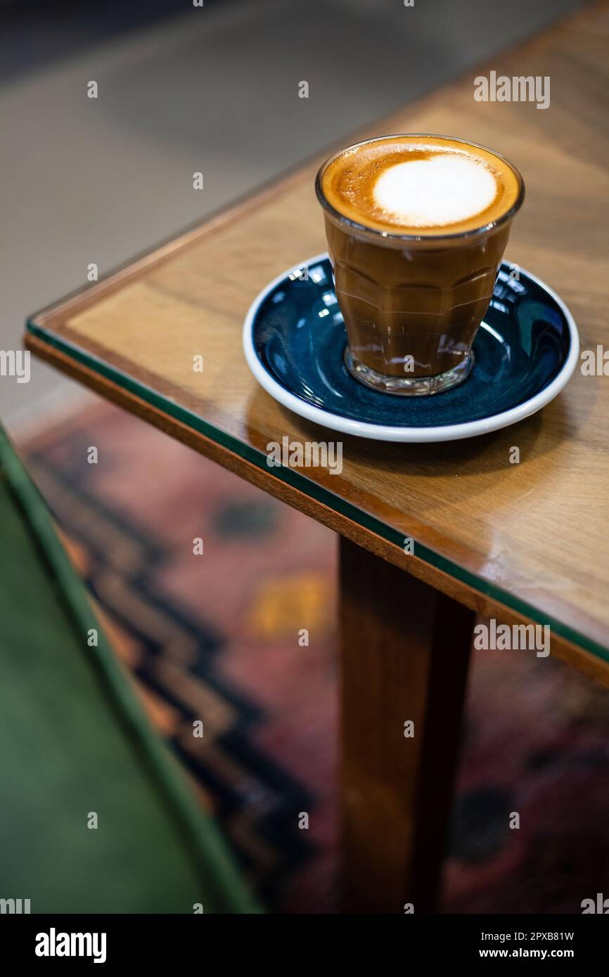 Un caffè sul lato del tavolo, un Macchiato sul bordo del tavolo. Foto Stock