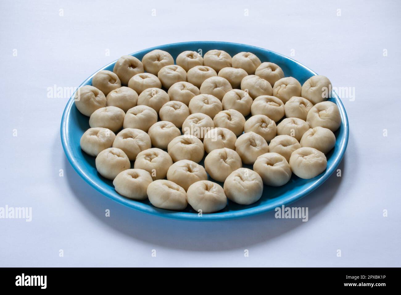 Un piatto di una piccola polpa di pasta di pane cruda appena fermentata fatta in casa su sfondo bianco Foto Stock