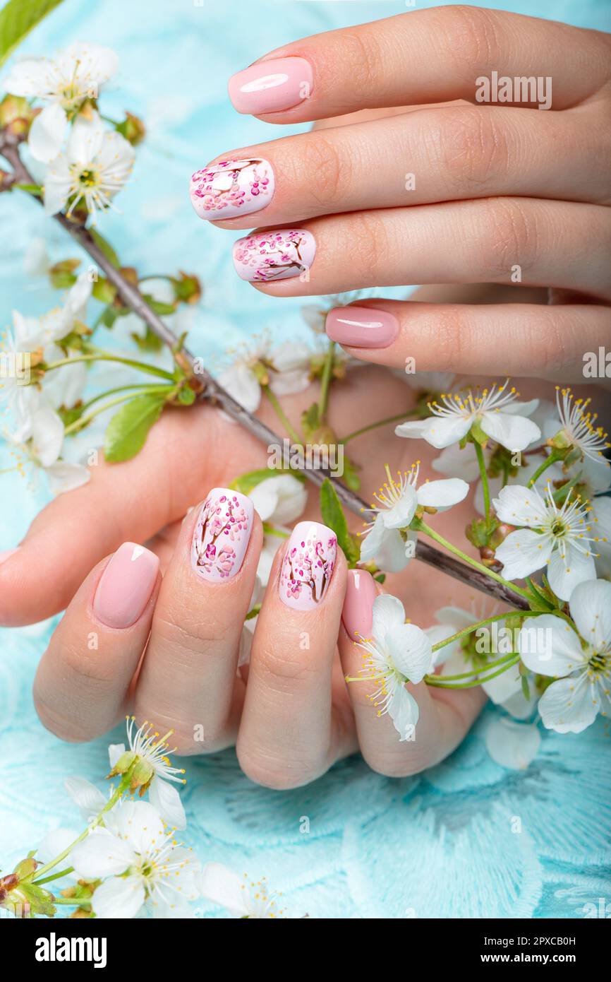 Manicure primaverile per la sposa in toni delicati con fiori. Progettazione di chiodi. Foto Stock