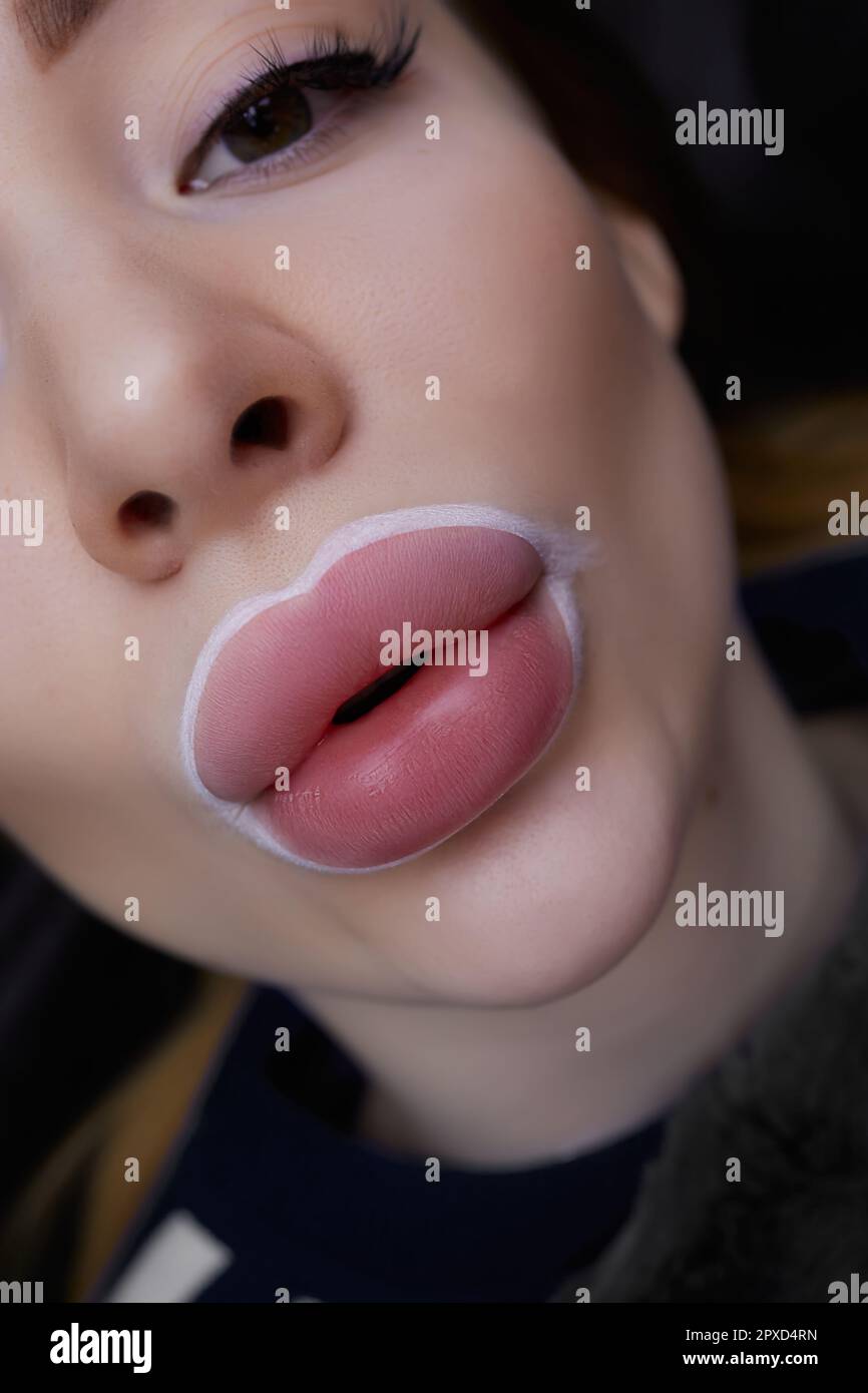 Una ragazza tira le labbra in avanti prima di una procedura permanente di  trucco labbra Foto stock - Alamy