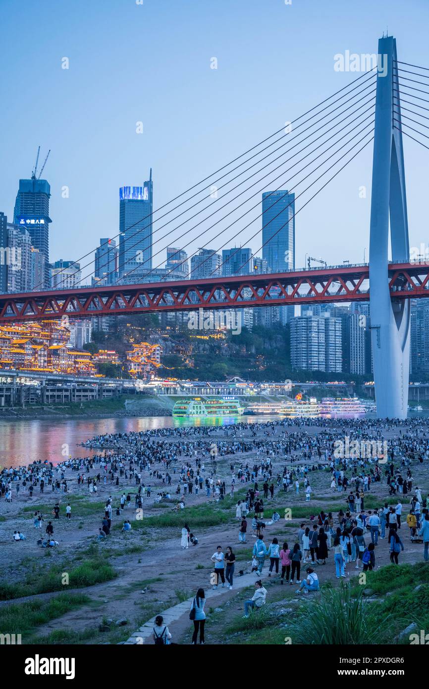 CHONGQING, CINA - 1 MAGGIO 2023 - i turisti godono di una vista notturna del punto panoramico della Grotta di Hongya e della città di montagna sulla riva del fiume di fronte a Hongyadong in CH Foto Stock