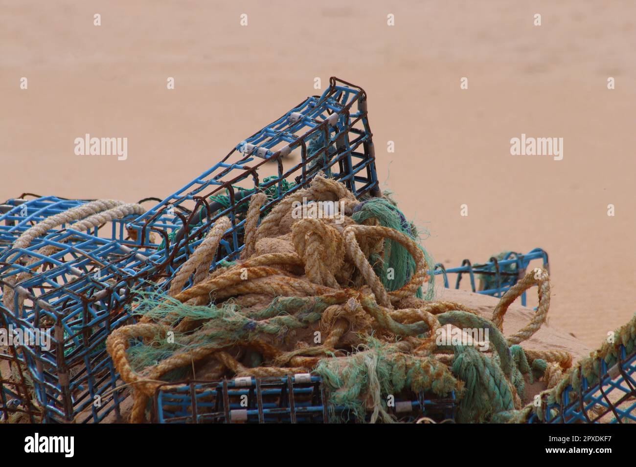 Pentole di aragosta e reti lavate in spiaggia Foto Stock