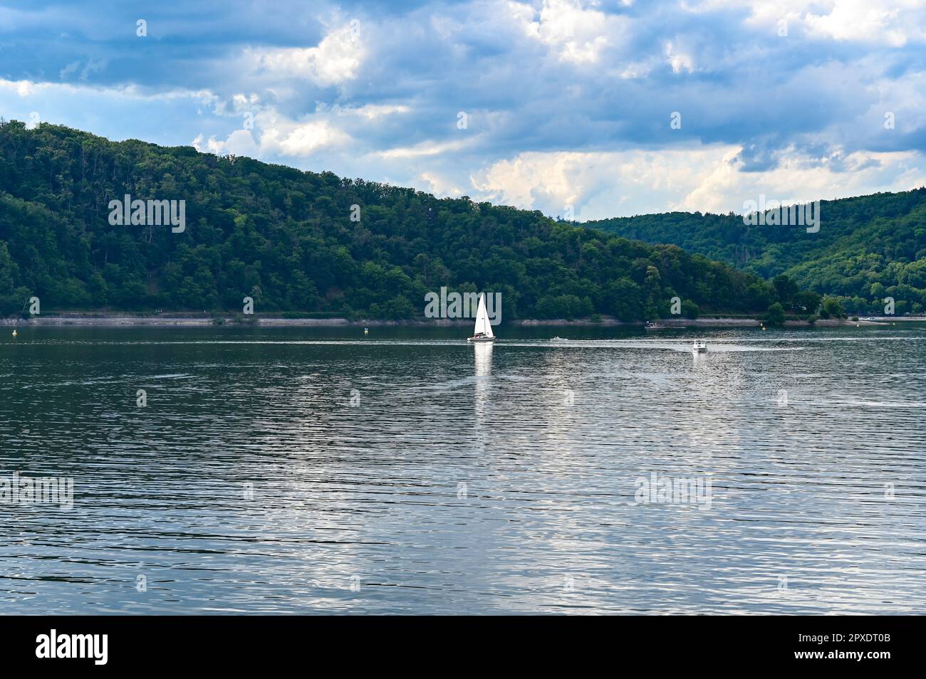 Vista del lago di Edersee dalla diga, con barche e navi a vela, con cielo blu e nuvole, in Assia, Germania Foto Stock