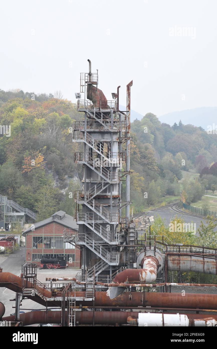 Un cantiere industriale con una serie di tubi che scendono lungo una collina Foto Stock