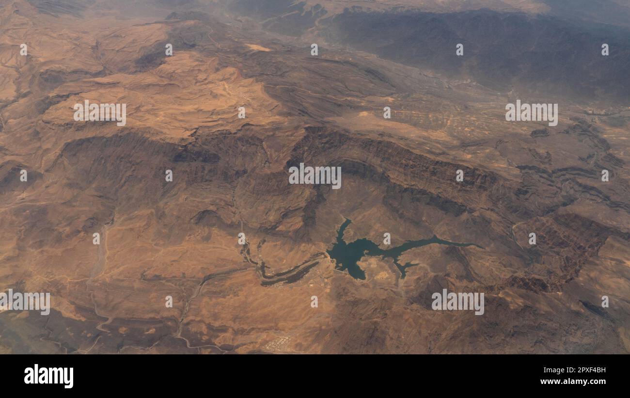 vista aerea di un fiume o di un corpo idrico in un paesaggio desertico aspro e drammatico nel medio-est. Foto Stock