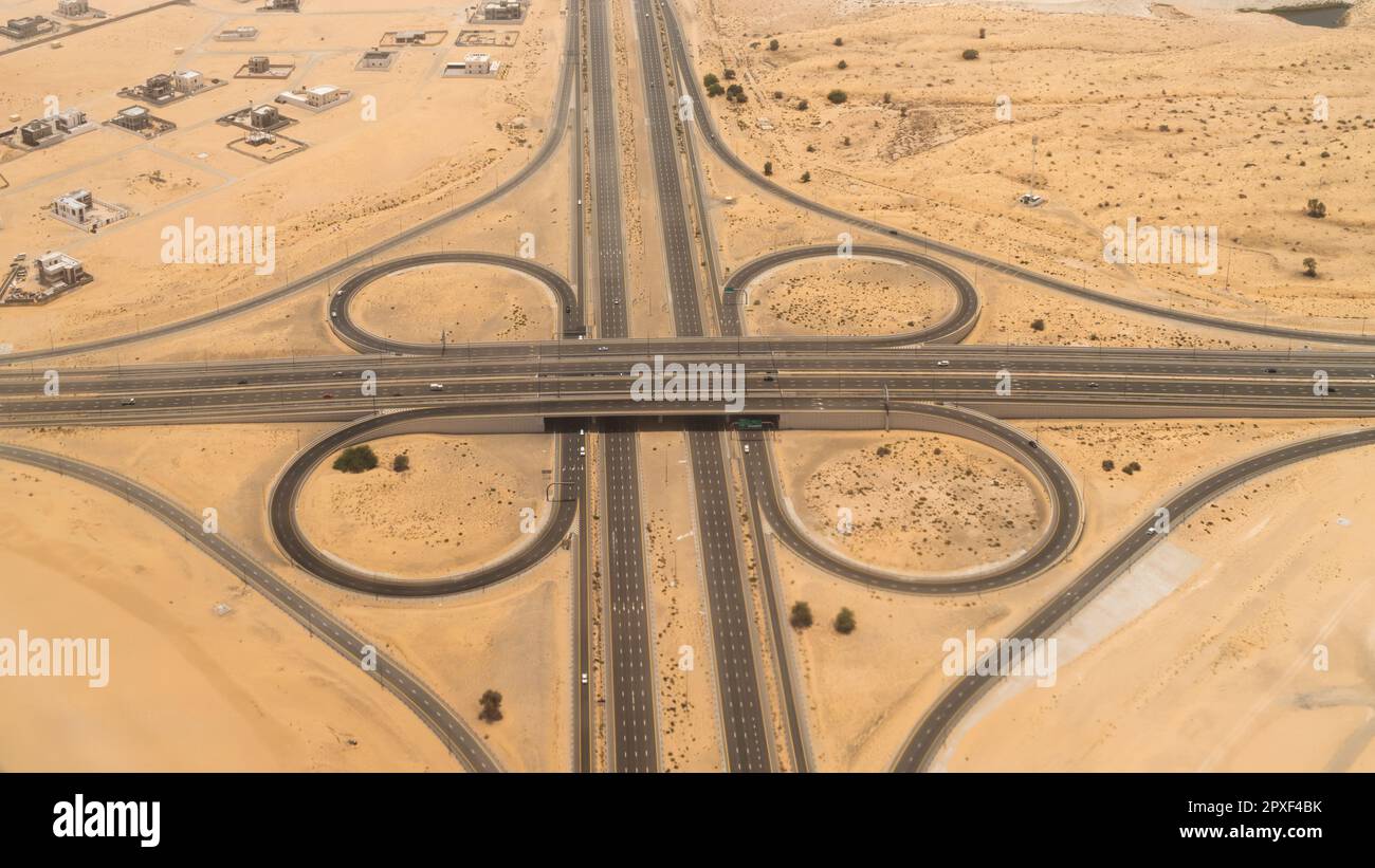 Veduta aerea di un interscambio autostradale elevato in un paesaggio desertico a Dubai, Emirati Arabi Uniti. Foto Stock